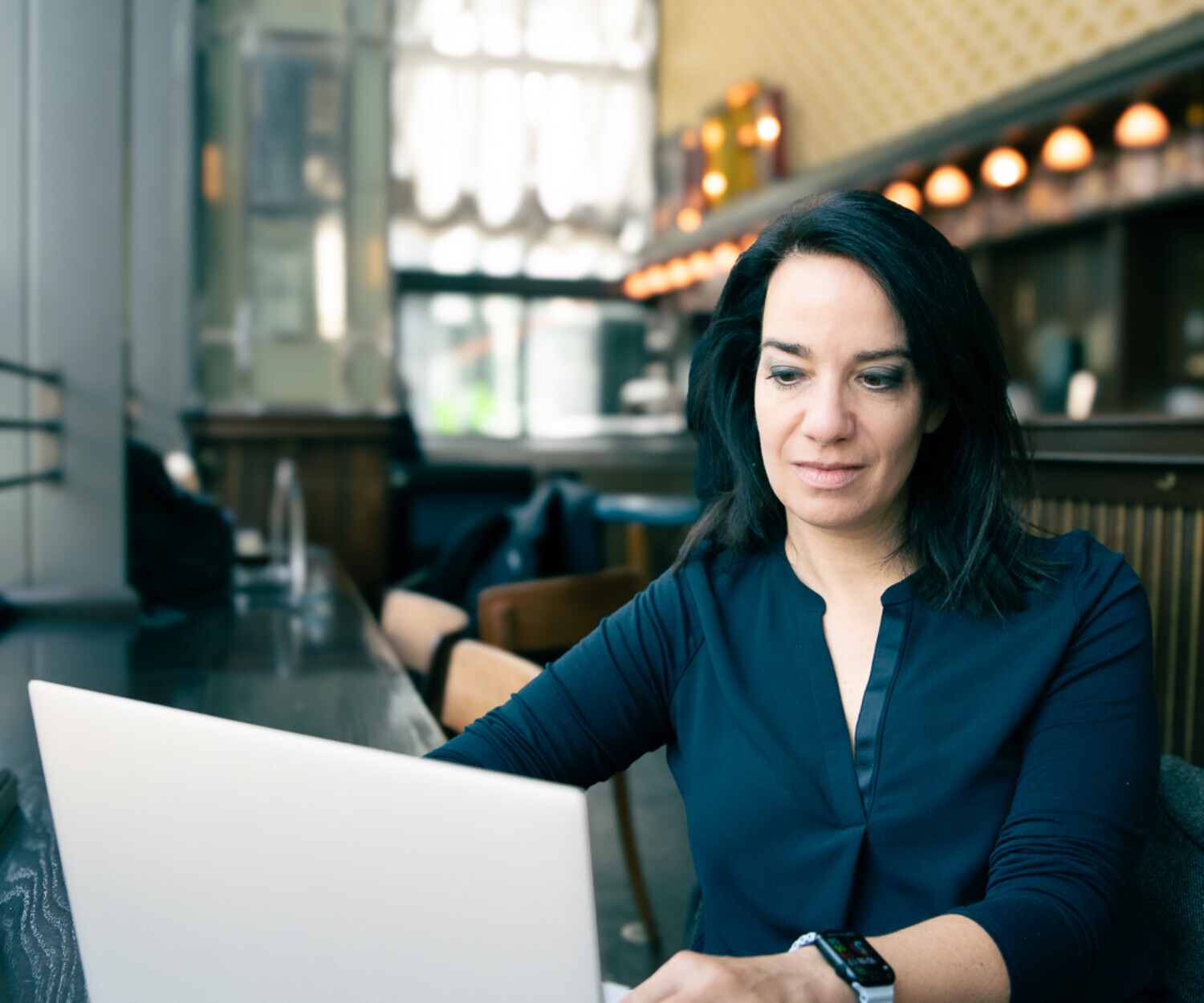 Linkedin Expertin an einem Laptop in einem Café