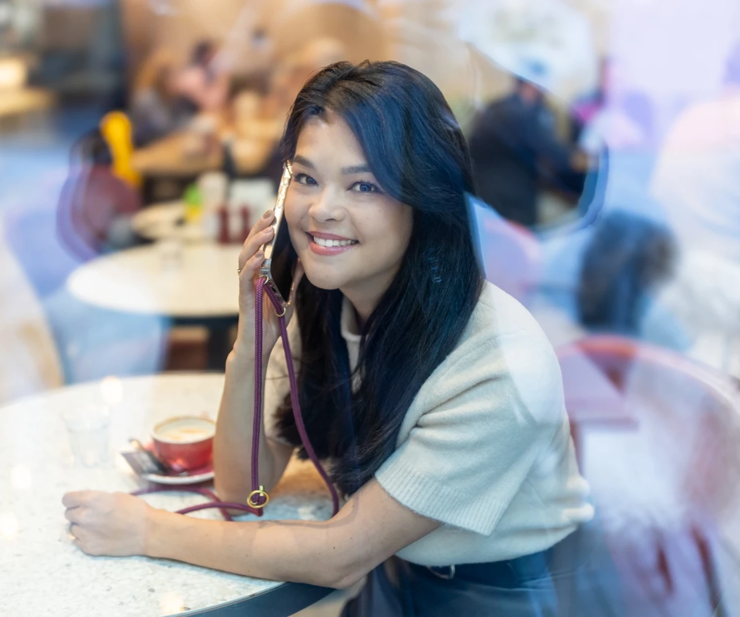 Frau an einem Handy in einem Café