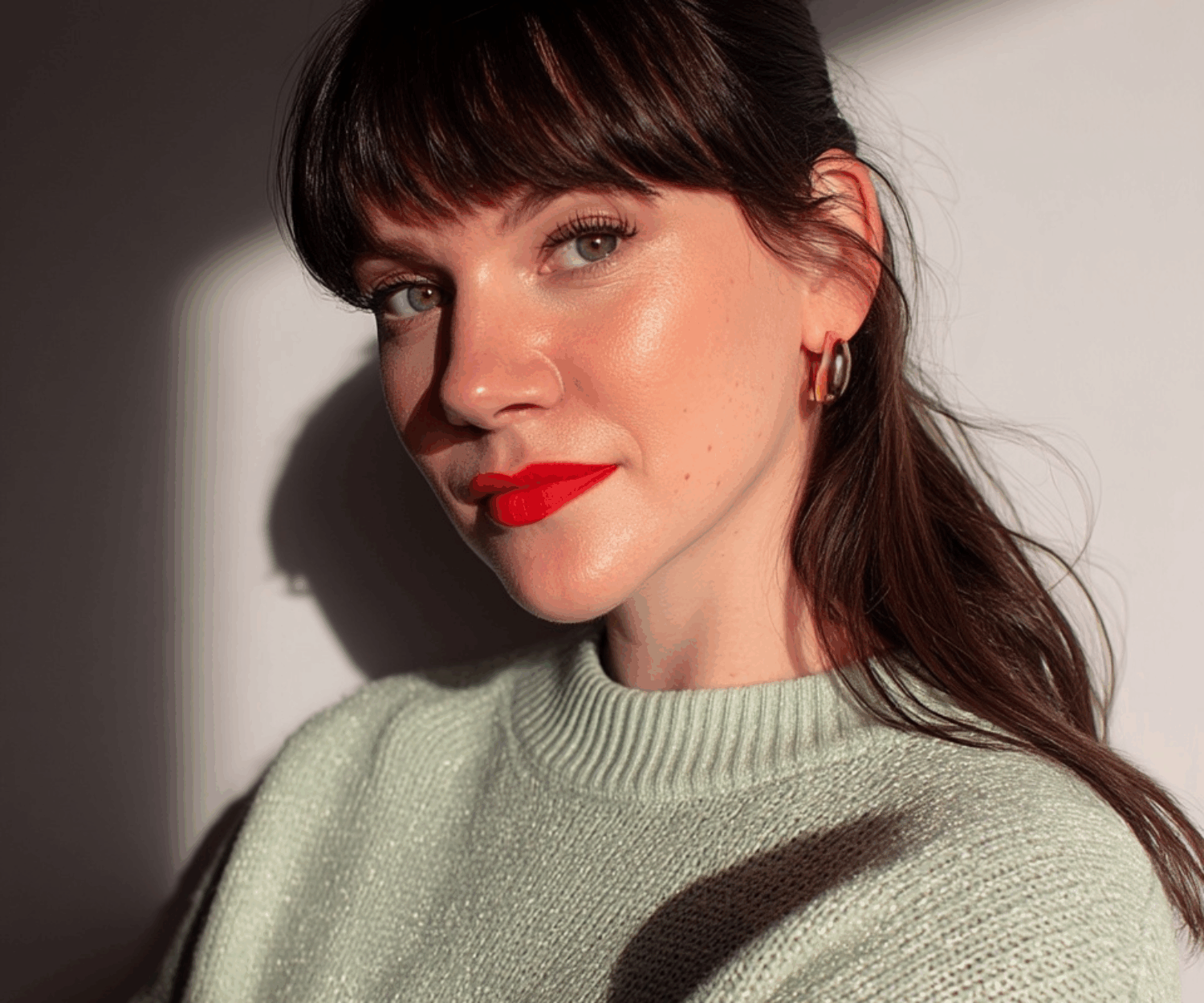 Portrait einer Frau in blassgrünem Pullover und langen braunen Haaren